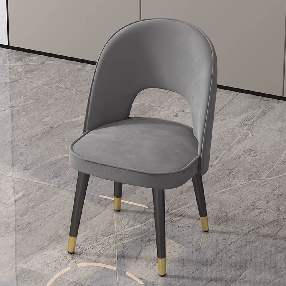 Sophisticated grey velvet dining chair with black legs and gold tips, designed for contemporary dining spaces.