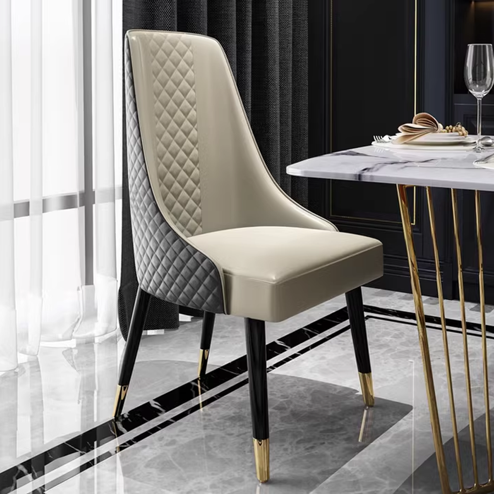 Modern upholstered dining chair with quilted backrest, leather seat, and black legs with gold tips