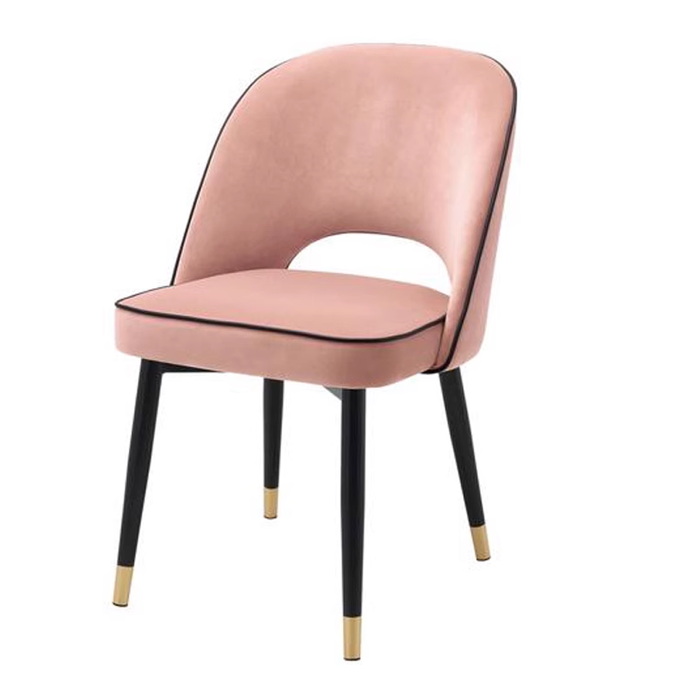 Chic pink velvet dining chair with black legs and gold accents, perfect for modern interiors.