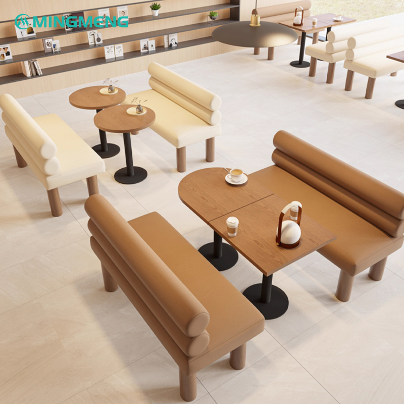 Long booth bench with brown leather seat and cream backrest in a minimal cafe setting