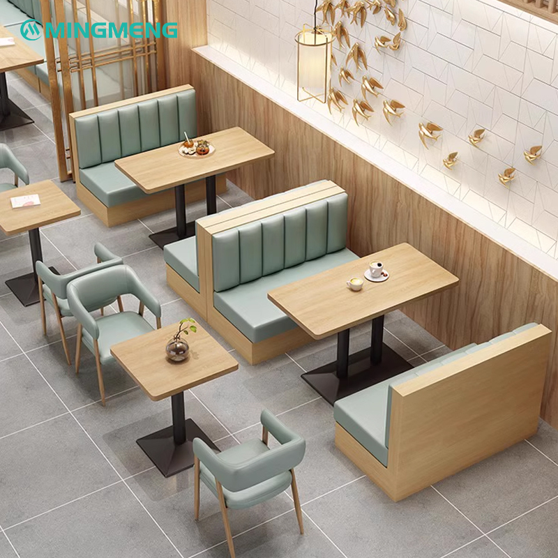 Stylish mint green restaurant booth set with wooden base and square dining tables in a contemporary setting.