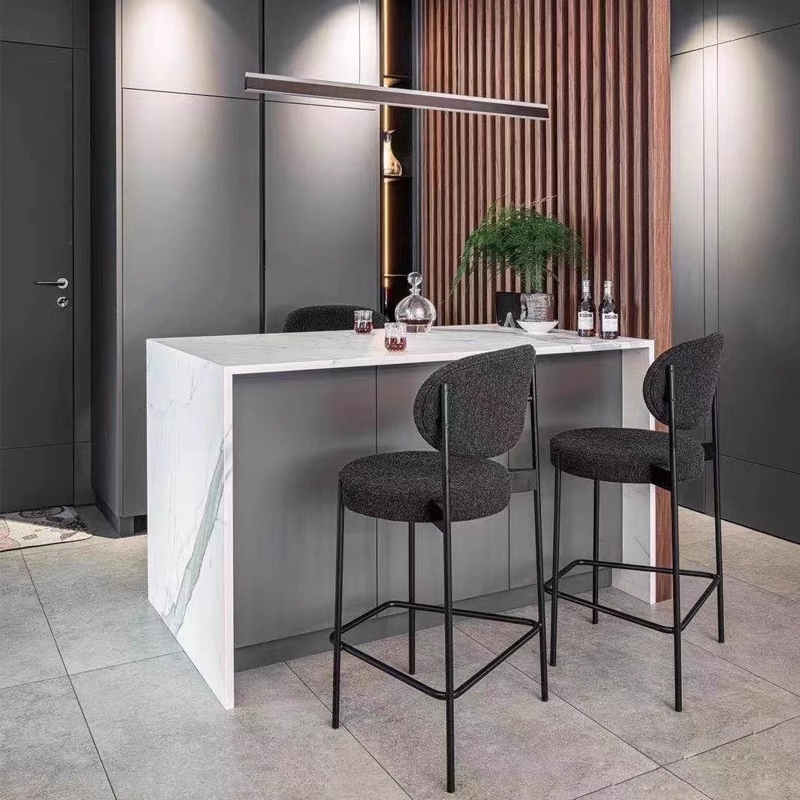 Set of modern upholstered bar stools with metal legs in a minimalist grey kitchen
