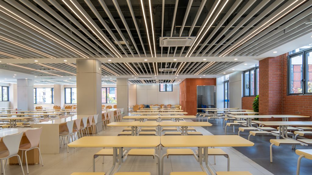 How to Choose the Best Cost-Effective Wooden Canteen Furniture in 20255 Spacious industrial canteen furnitures seating featuring white tables and yellow chairs, designed for an open dining environment.
