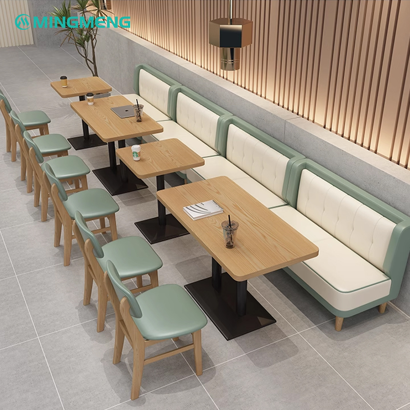 Modern restaurant booth seating with green cushions and wooden legs, ideal for restaurants and cafes.
