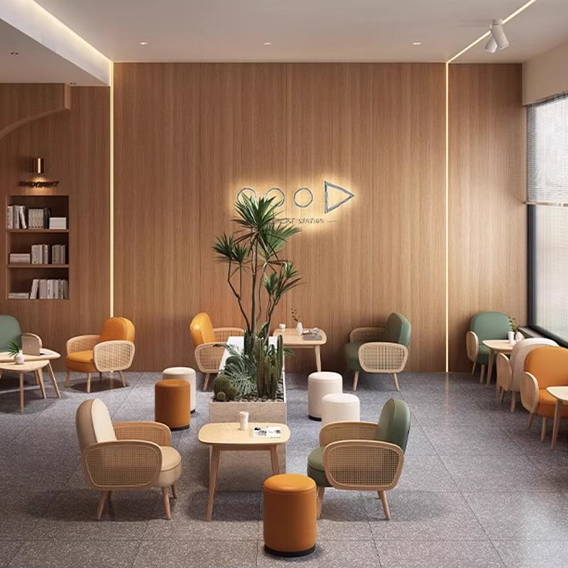 Cream-Colored Booth with Rattan Armrests1 Contemporary canteen seating featuring wooden tables and vibrant chairs.