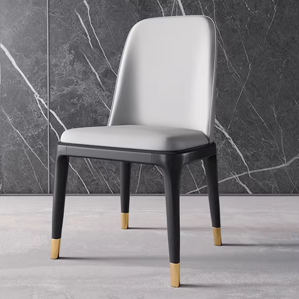 Modern white leather dining chair with black legs and gold tips, stylish and elegant design