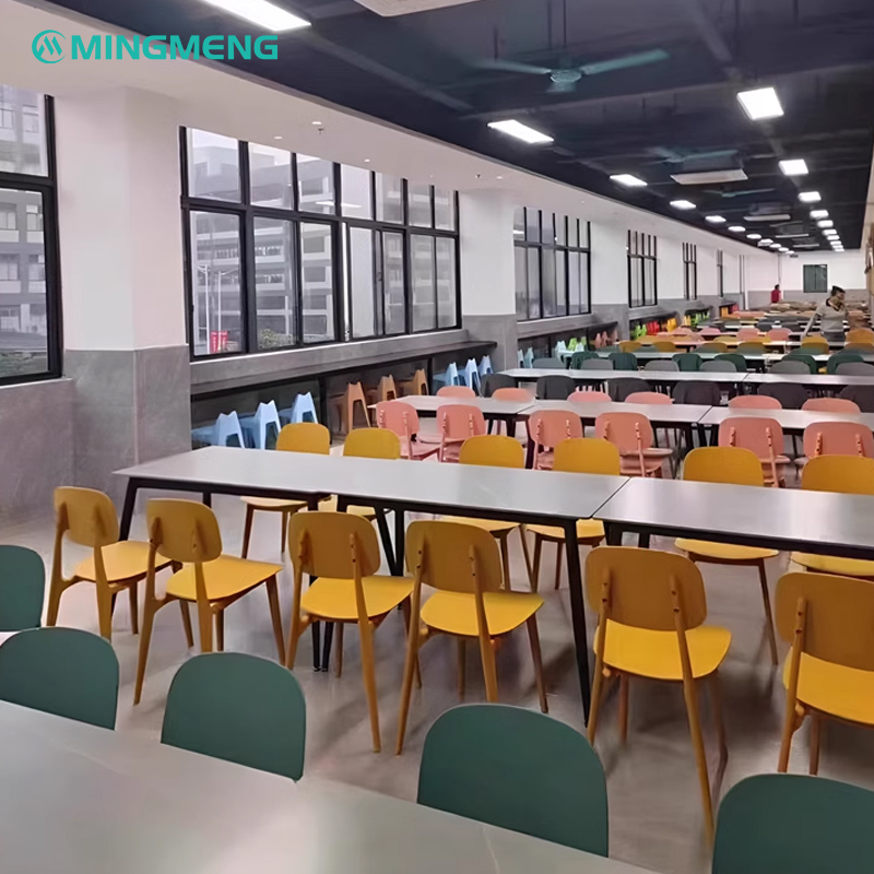 Wide dining hall filled with colorful plastic canteen chairs and long rectangular tables, ideal for school or factory cafeterias