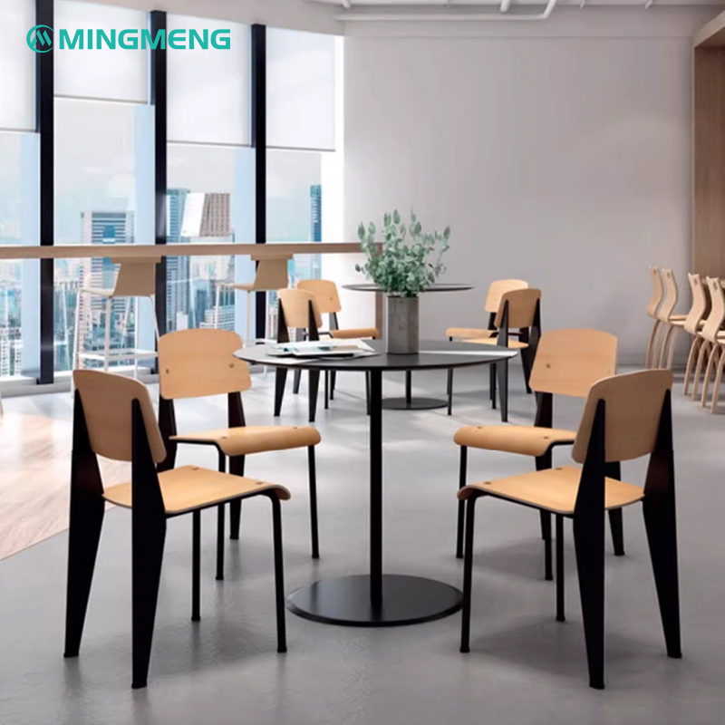 Contemporary canteen setup in an office with round black tables and light wooden canteen chairs around them