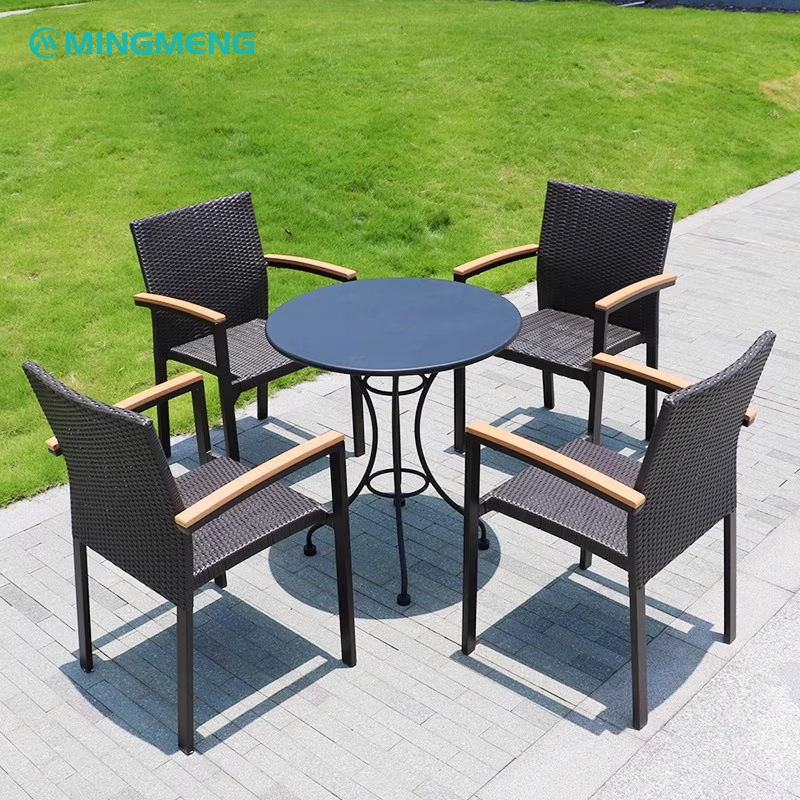 Round black table with 4 outdoor rattan bistro chairs on garden patio
