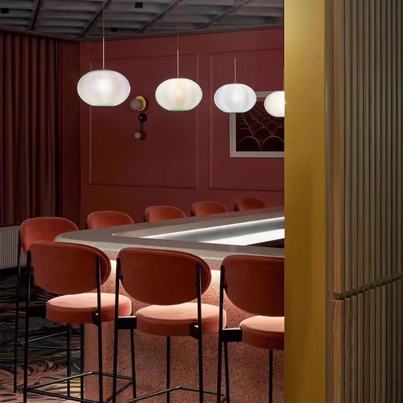 Velvet pink upholstered bar stools at modern bar with terrazzo counter