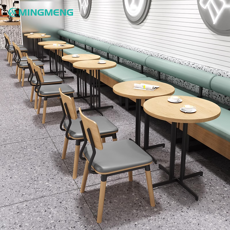 Restaurant booth seating with grey cushions and wooden tables in a minimalist style