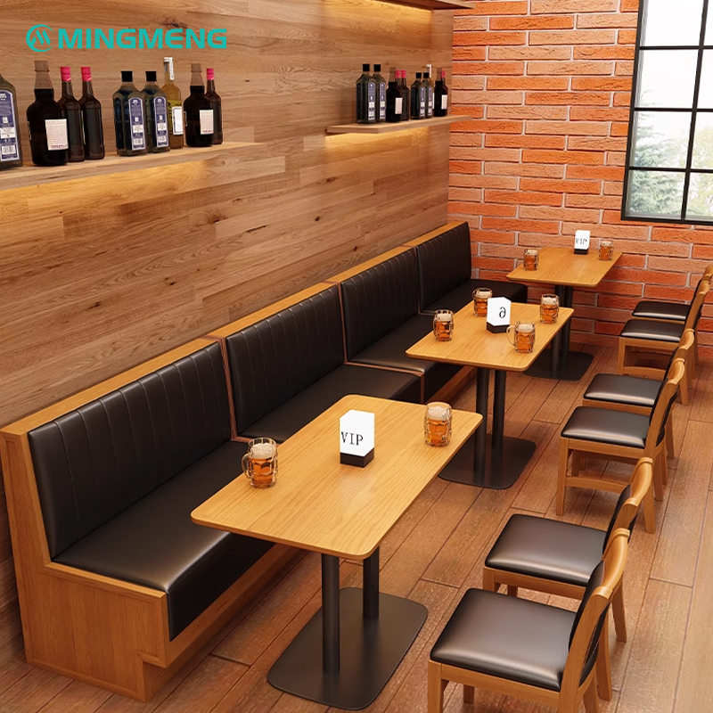 Long black cushioned restaurant booth along wood-paneled wall with square tables and chairs