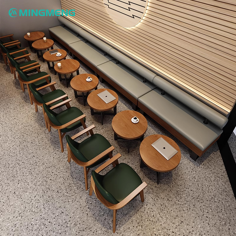 Restaurant booth seating with green cushions and chairs, featuring wooden tables and modern design