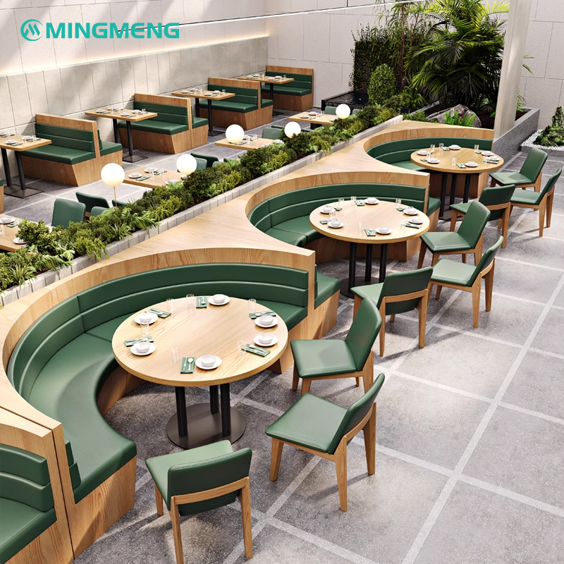 Curved restaurant booth with green cushions and wooden base, designed for modern dining areas