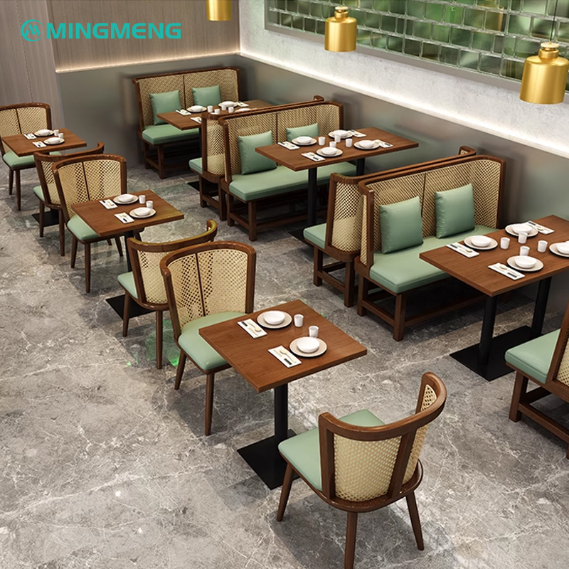 Modern restaurant dining area with wooden tables, green cushions, and minimalistic design