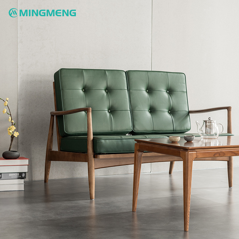 Scandinavian two-seater sofa in green leather and fabric, ideal for minimalist dinding room decor.