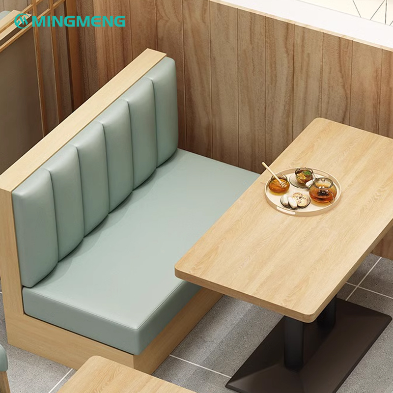 Compact single mint green restaurant booth with vertical channel backrest and wooden dining table.