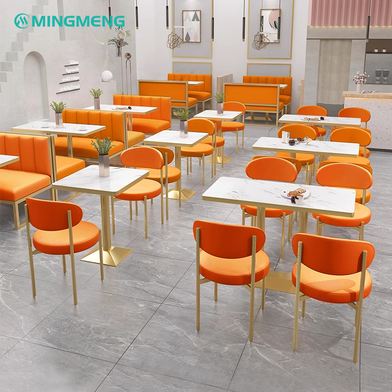 Multiple rock slab dining table sets with orange chairs in a stylish café