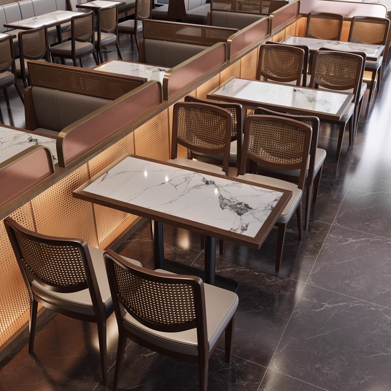 Restaurant interior with white sintered stone tables paired with square rattan-back dining chairs and booth seating