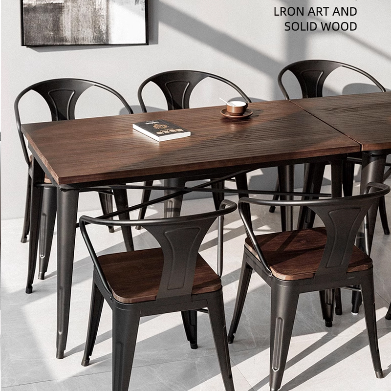 Solid wood rectangular dining table with black metal frame and matching chairs in a modern restaurant