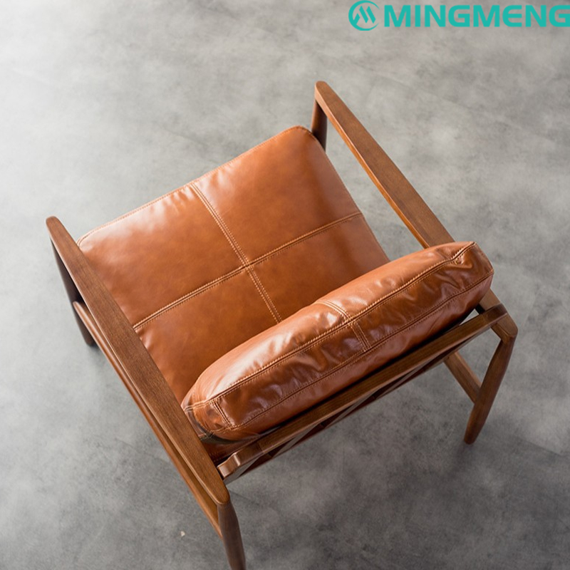 Top view of mid-century lounge chair showing padded leather cushions and walnut wood structure