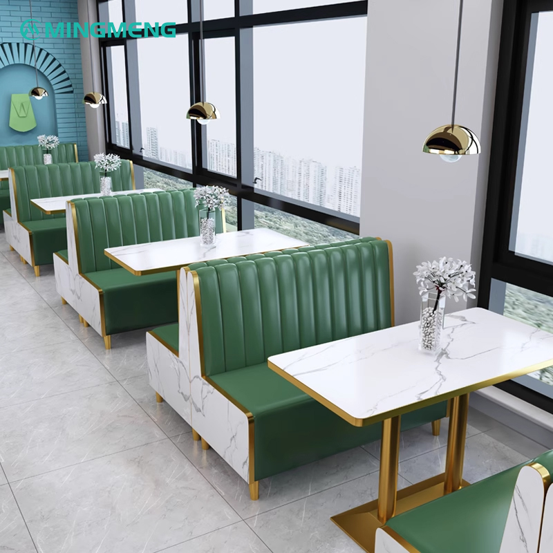 Green leather booth sofa by the window with a white marble table, perfect for modern restaurants