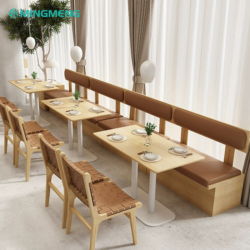 Wooden bench-style booth seating by the window, upholstered with brown leather cushions