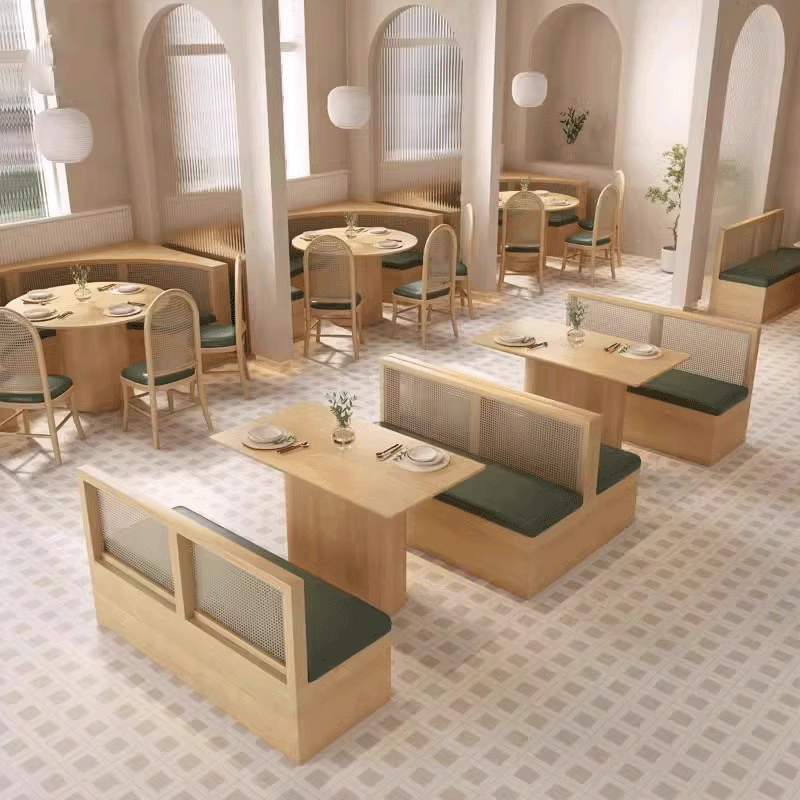 Dining area with wooden tables, rattan chairs, and green cushions, arranged for a modern and inviting dining experience