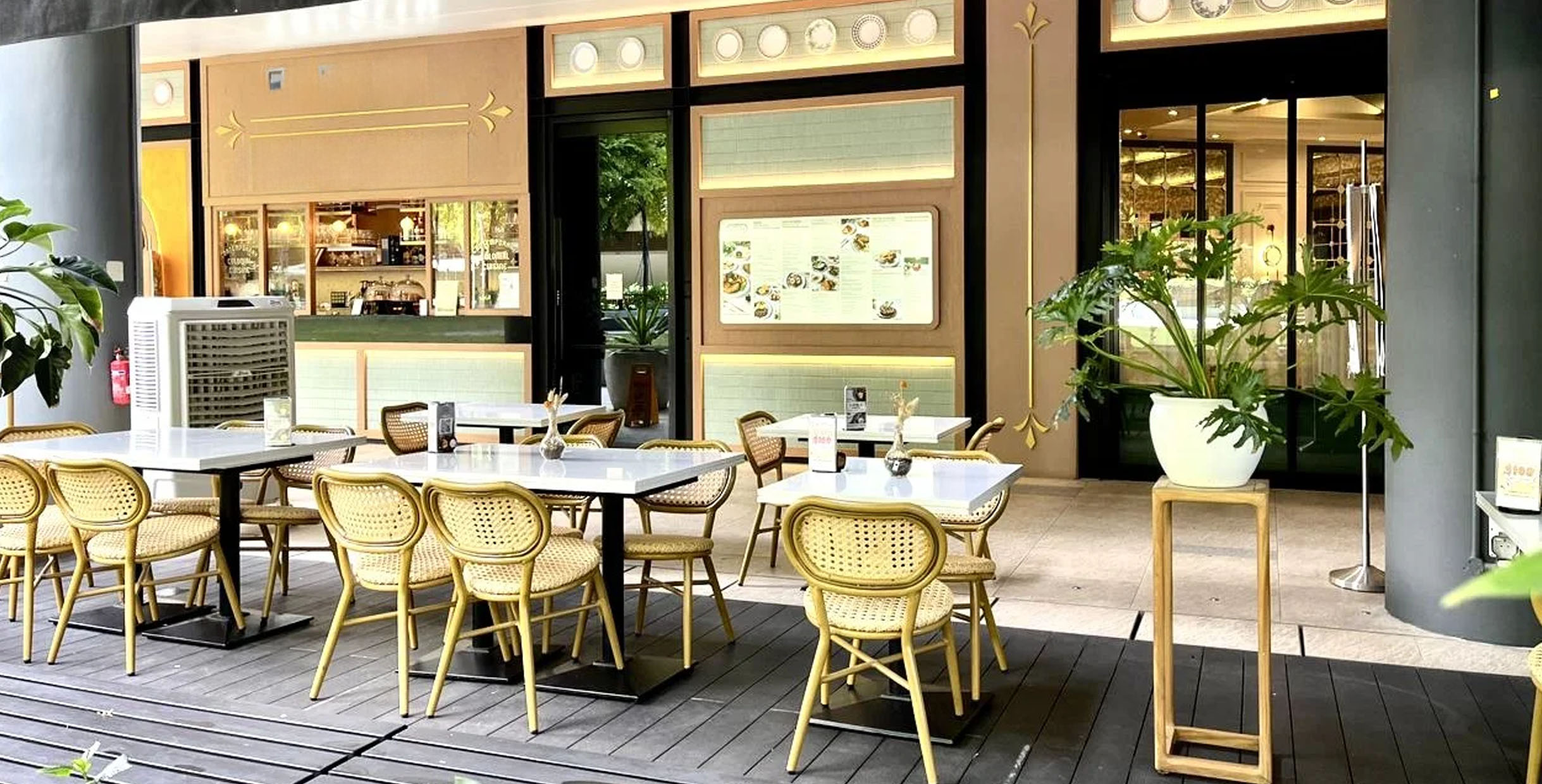 Outdoor cafe dining set featuring rattan chairs and white tables, perfect for casual al fresco dining.
