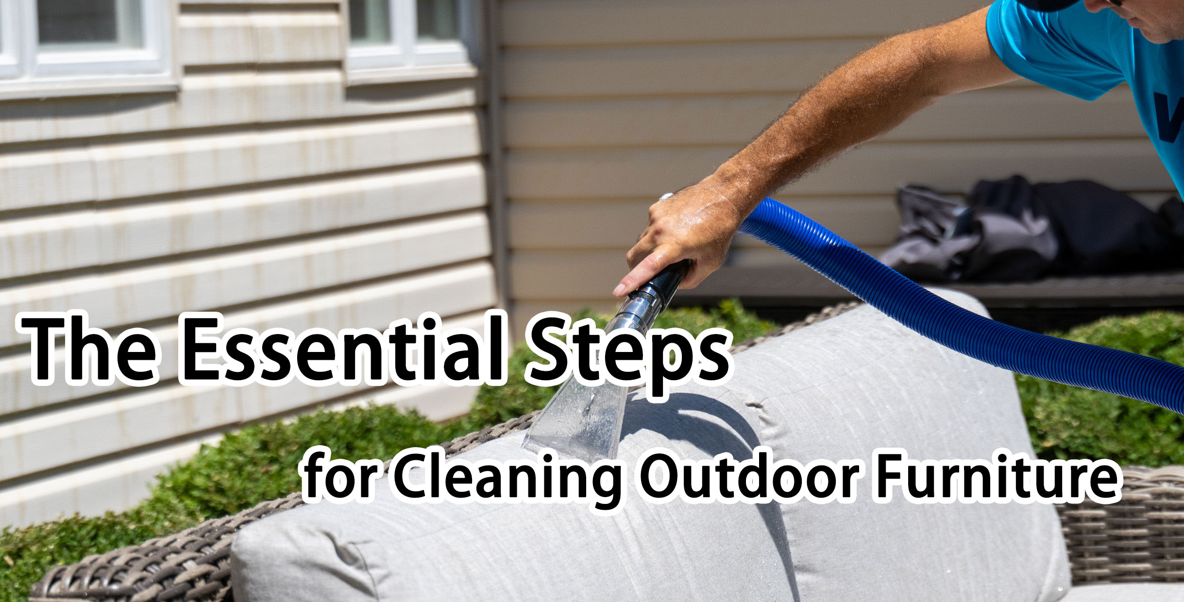 Man cleaning outdoor restaurant furniture cushion with vacuum hose