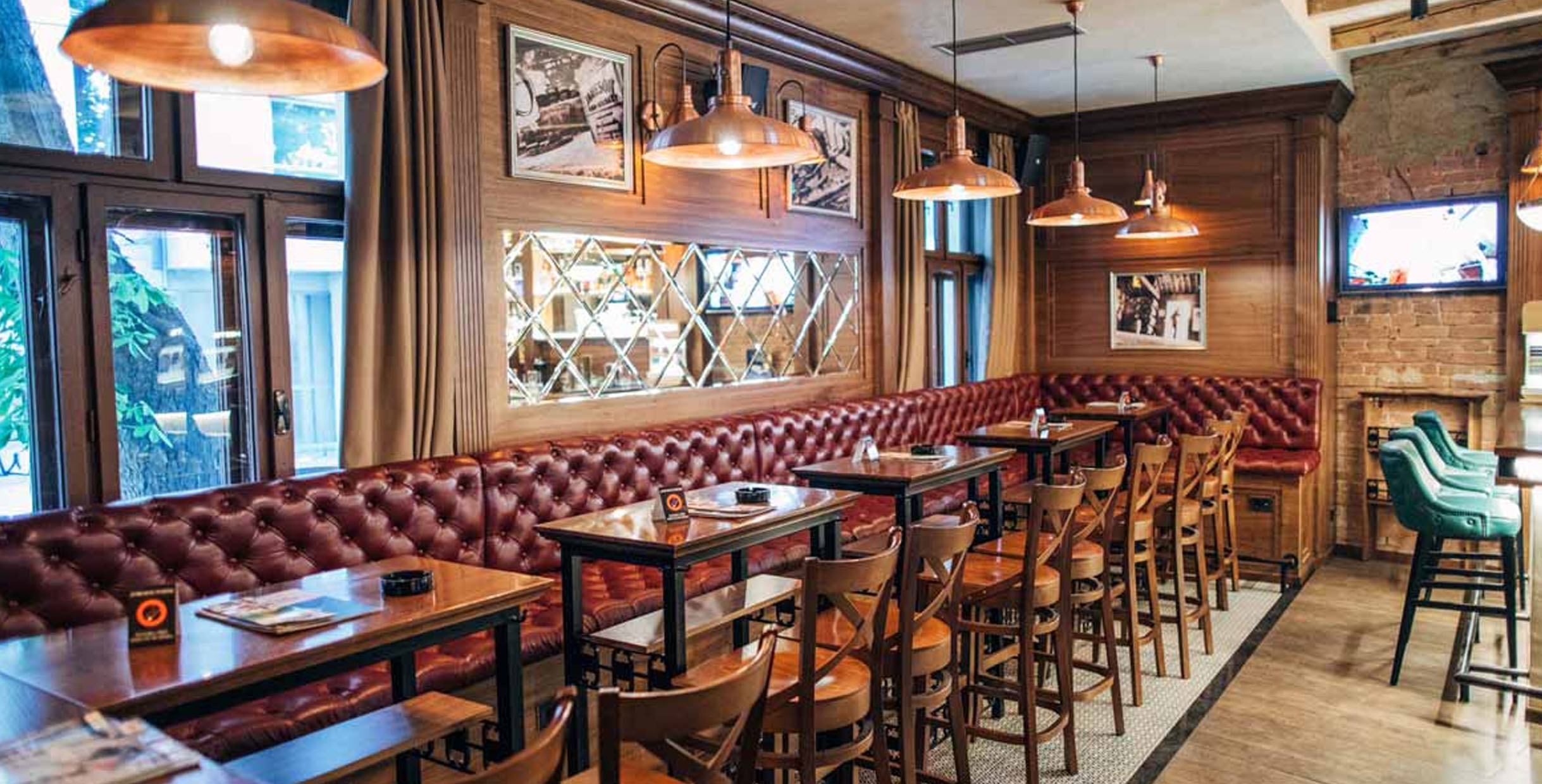 Leather booth seating with wooden tables in a cozy restaurant interior