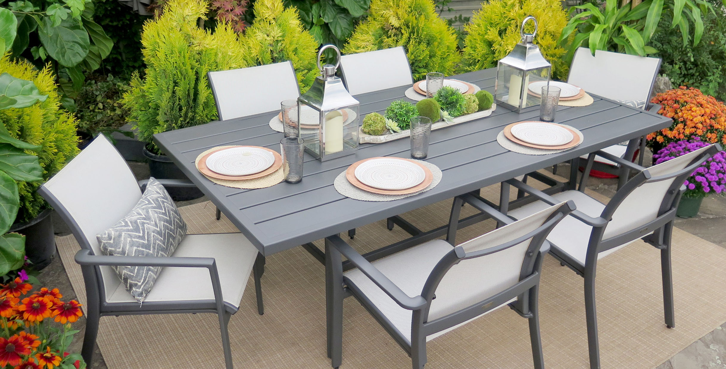 Stylish outdoor dining set featuring a grey table and comfortable chairs, perfect for restaurants or garden spaces