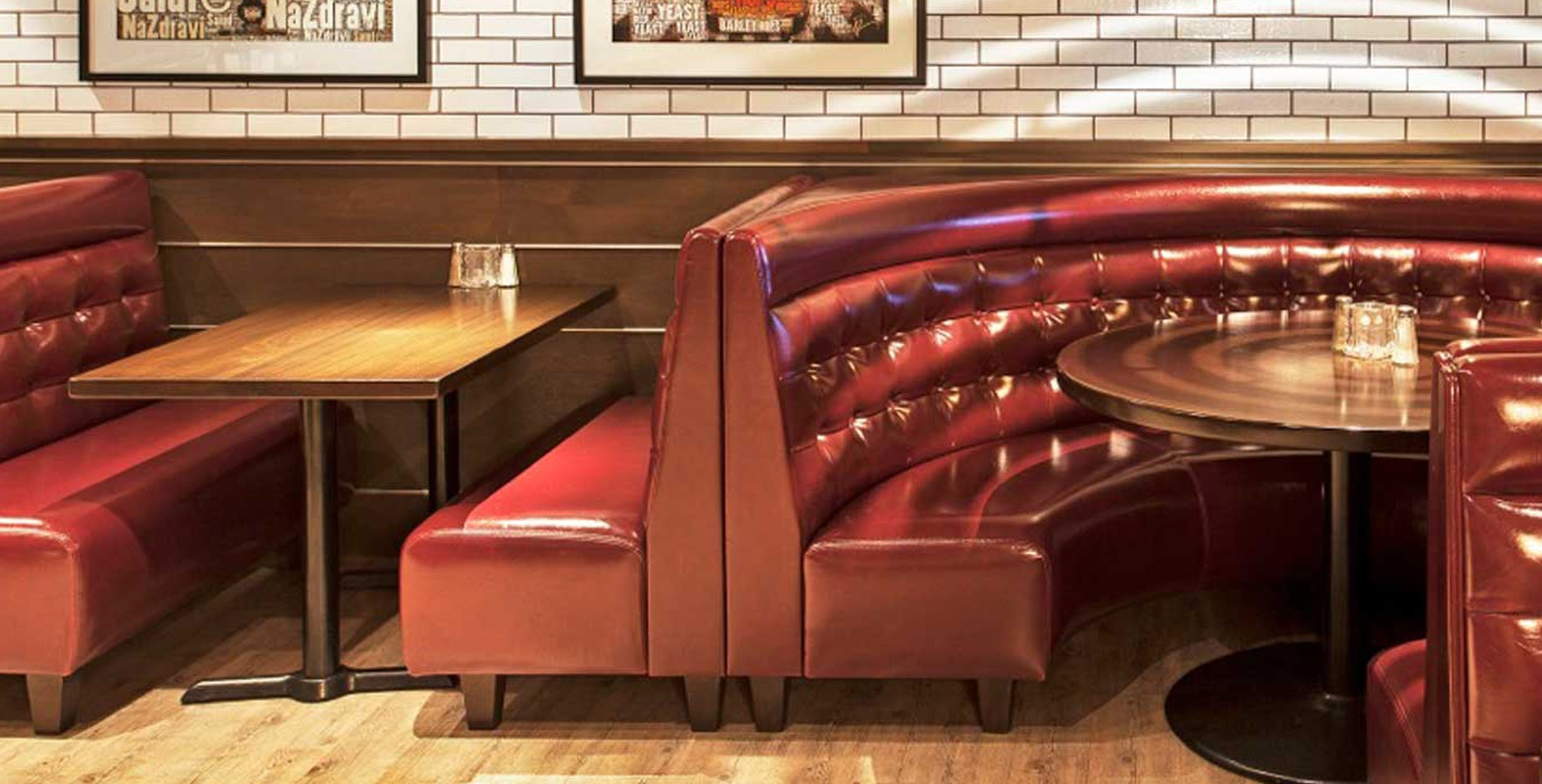 Red leather booth seating with wooden table in a cozy restaurant setting