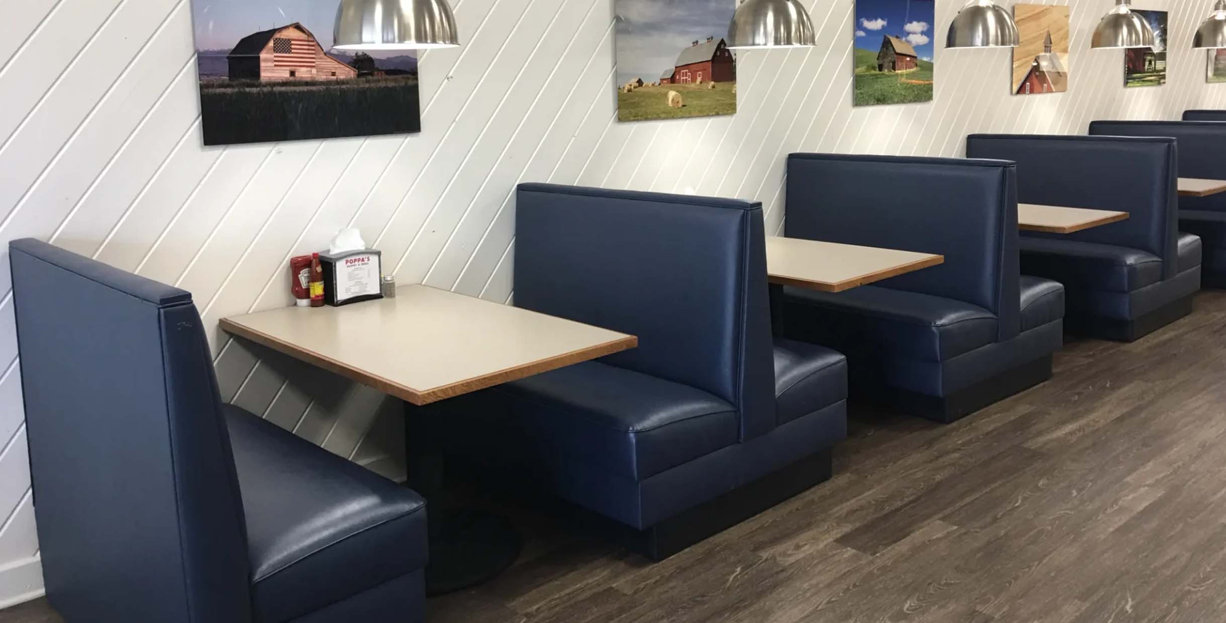 Blue leather restaurant booth with clean, simple design and light wood tables