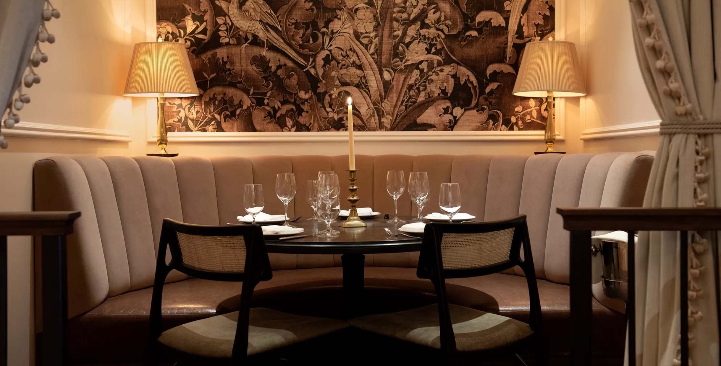 Elegant cream upholstered restaurant booth sofa with round dining table and elegant decor