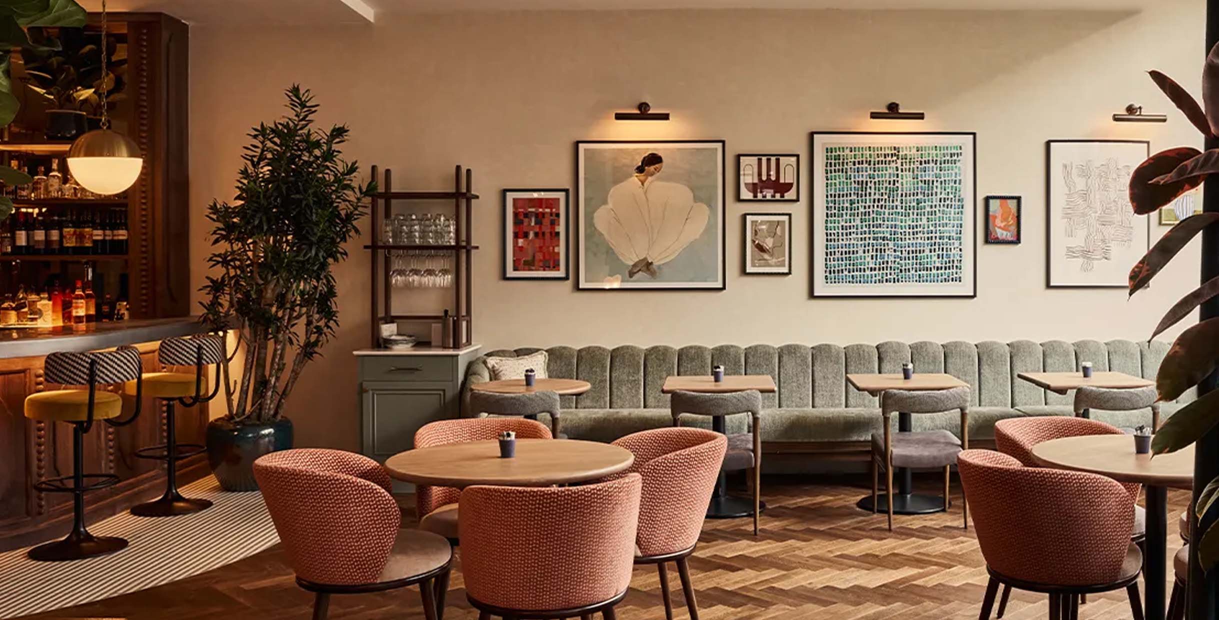 Modern restaurant booth sofa with soft upholstered backrest and wood dining tables in a stylish café setting.