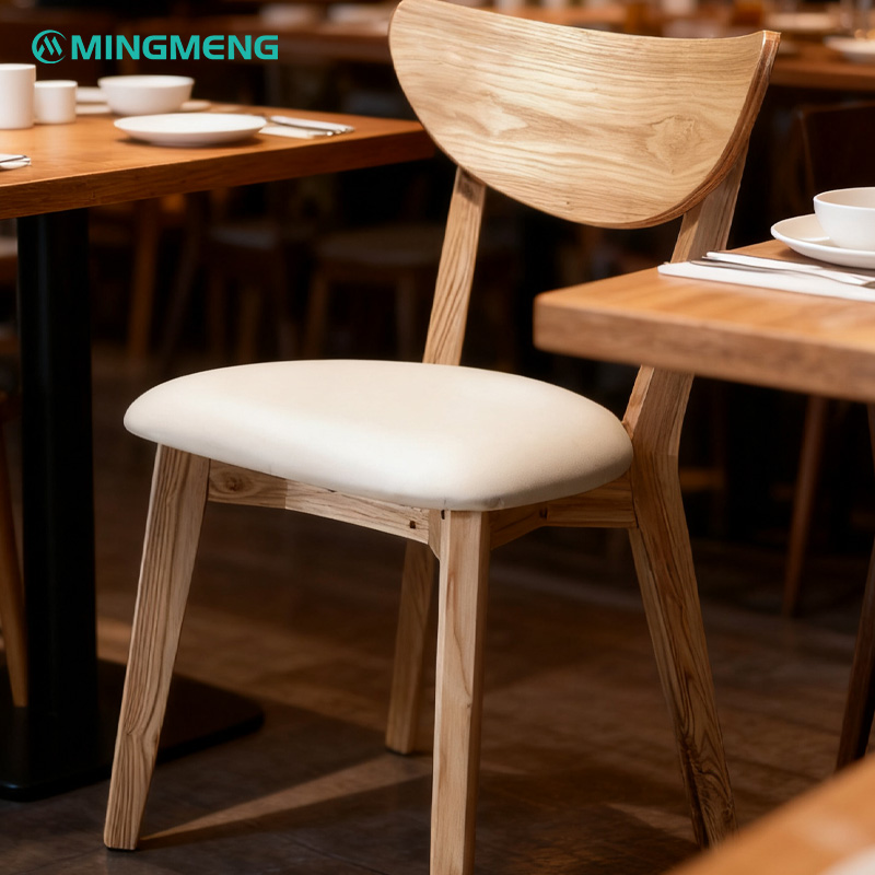 Light Wood Frame with Curved Backrest Restaurant Chair Wooden restaurant chair with white cushioned seat in dining setting