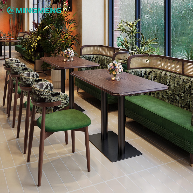 Retro Horn Chair – Chenille Jacquard Backrest with Green Fabric Seat1 Retro horn restaurant chairs with green upholstered seats and palm leaf patterned backrests paired with wooden dining tables and booth seating in a modern restaurant.