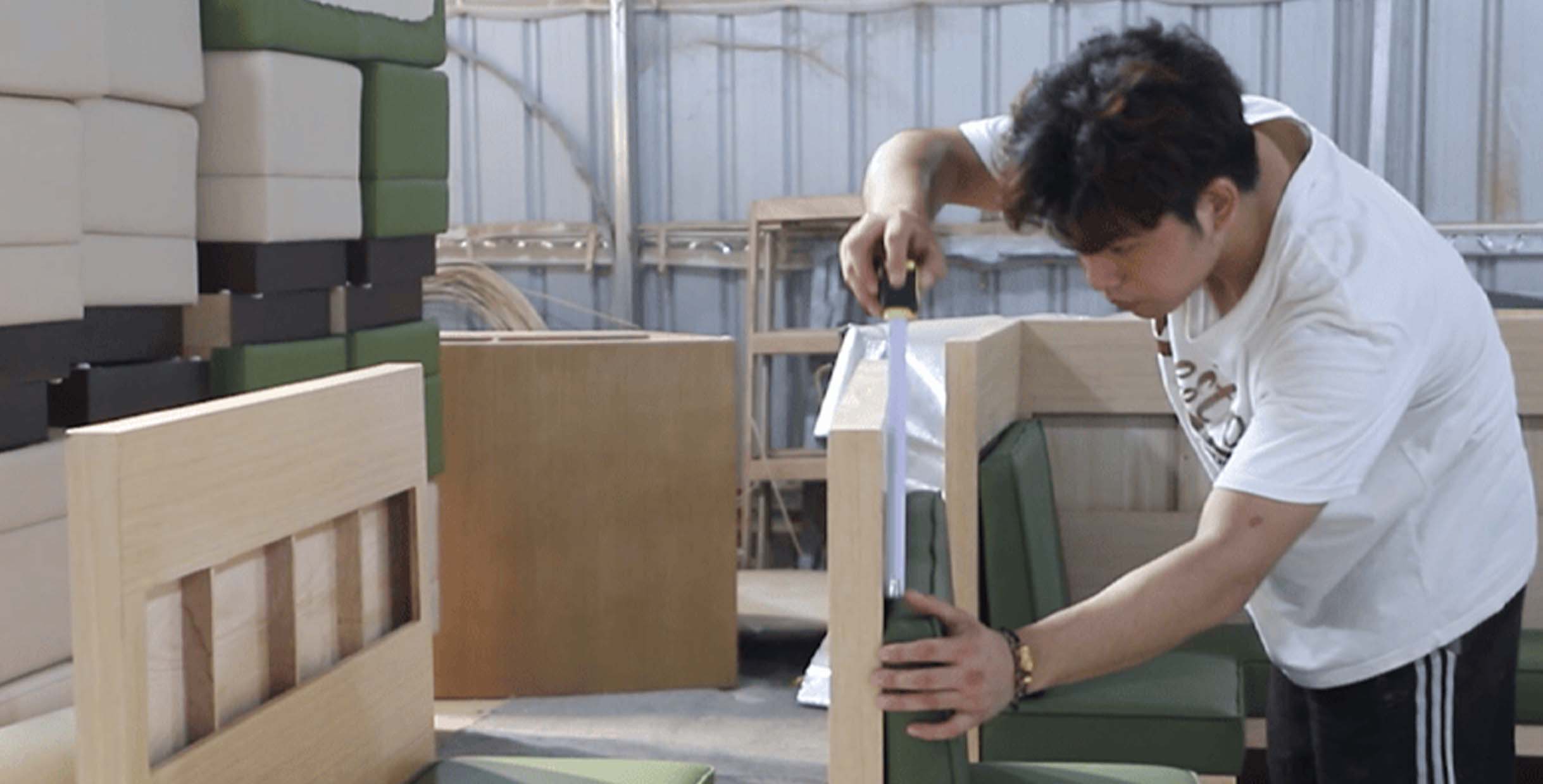 How to Source Commercial Restaurant Supplies Furniture Directly from Factory3 Quality control engineer inspecting and measuring restaurant booth upholstery at Mingmeng factory before export, ensuring durability, precision, and finish consistency.
