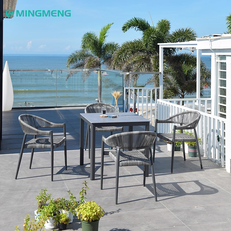 Modern Yadu Outdoor Patio Rattan Chair3 Modern Yadu outdoor rattan dining set with four chairs and square table by MINGMENG on a beachfront patio