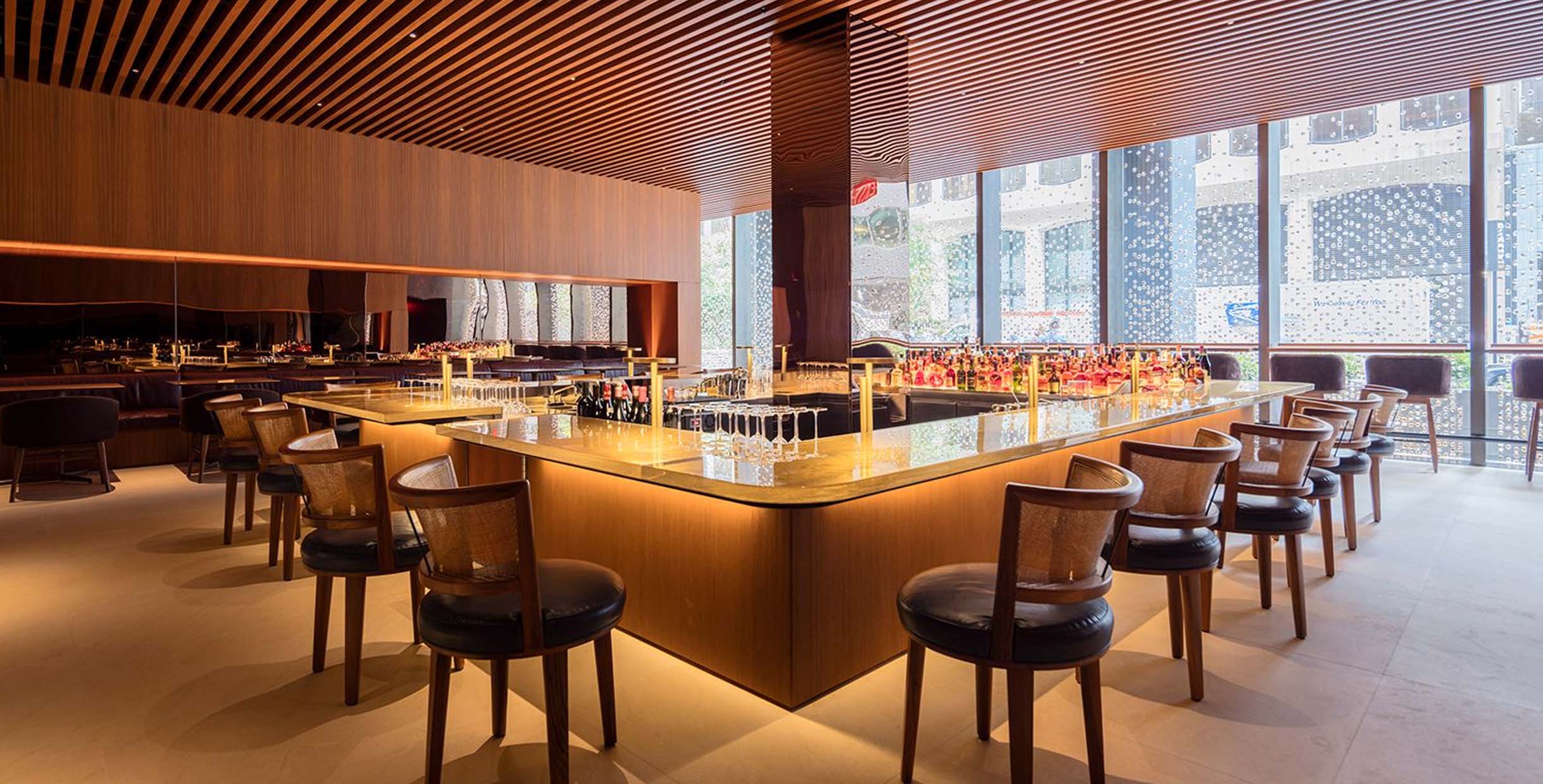 How to Source Commercial Restaurant Supplies Furniture Directly from Factory8 Elegant restaurant bar interior featuring Mingmeng custom-made wood tables and upholstered bar chairs, designed for modern hospitality spaces with warm lighting and premium finishes.