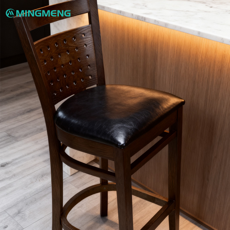 Custom Solid Wood Bar Stool – High Back Design with Perforated Backres Mingmeng wooden bar stool with perforated backrest and black leather seat placed beside marble counter
