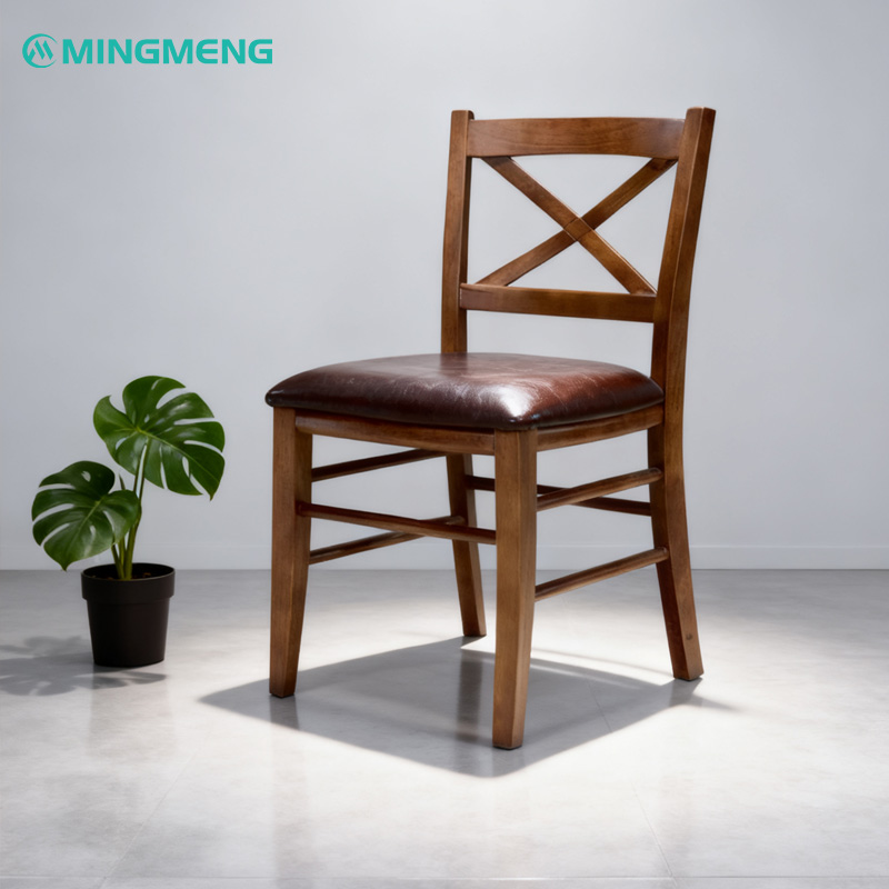 Classic X-Back Solid Wood Restaurant Chair Mingmeng X-back wooden restaurant chair with brown leather cushion, placed in a minimalist studio setting with a potted plant for modern restaurant interiors.