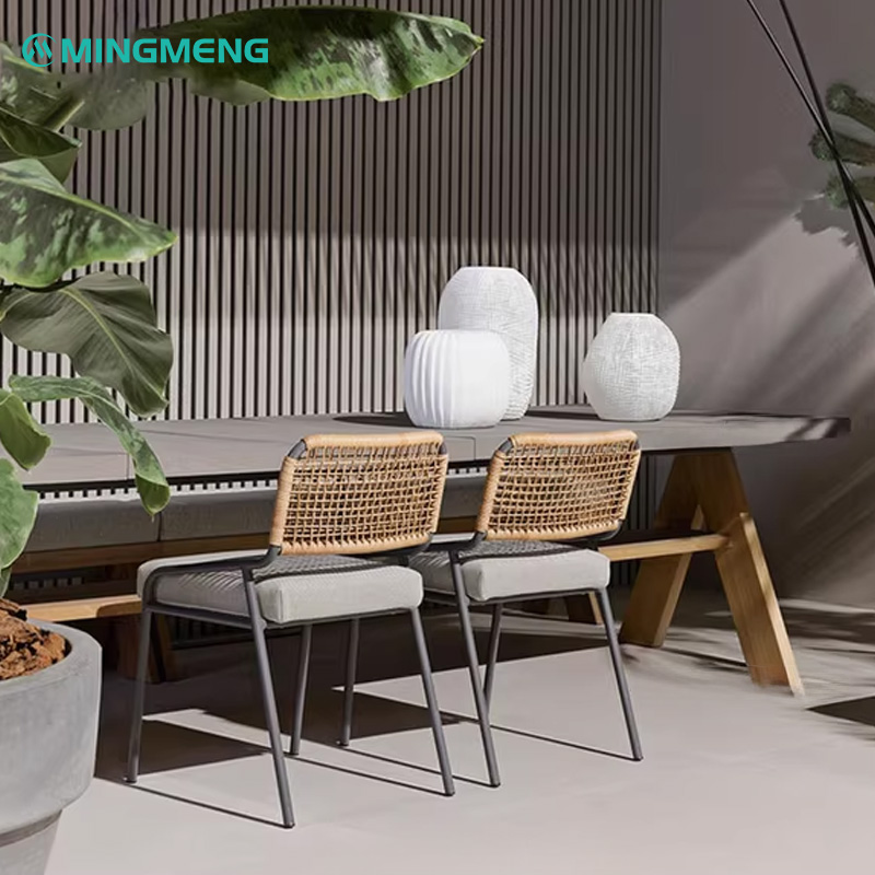 Custom Nordic Outdoor Rattan Dining Chair1 Outdoor dining table with woven chairs, modern patio design with large planters and white vases.