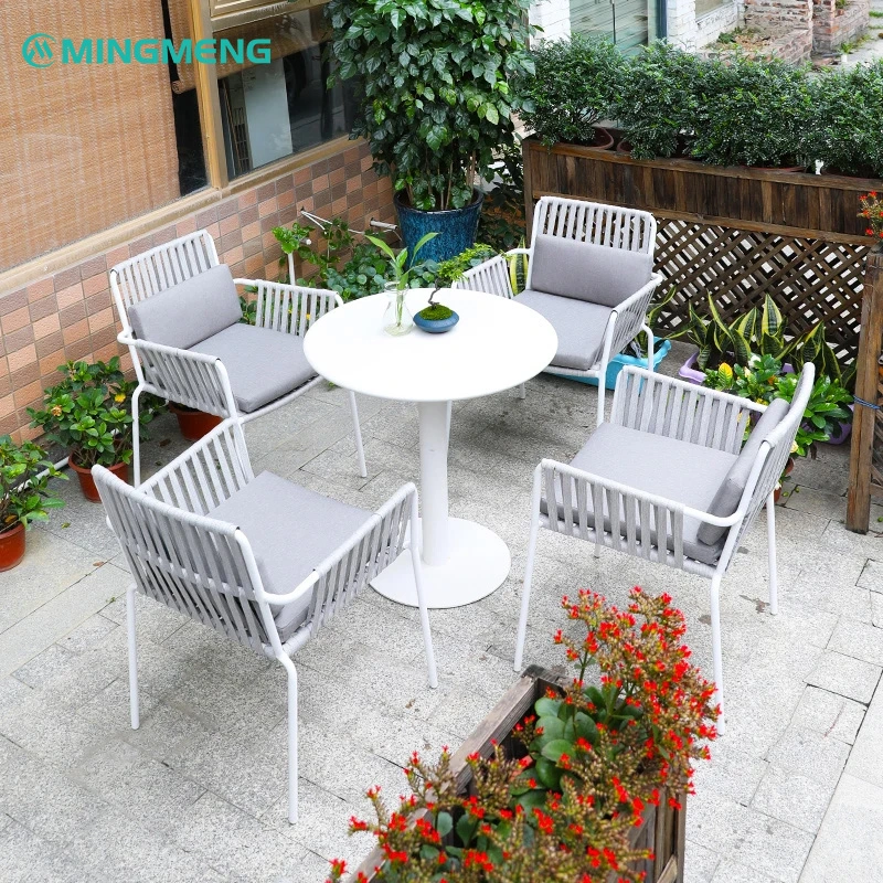 Custom White Outdoor Garden Dining Table3 White outdoor round table and chairs set with grey cushions in a garden setting