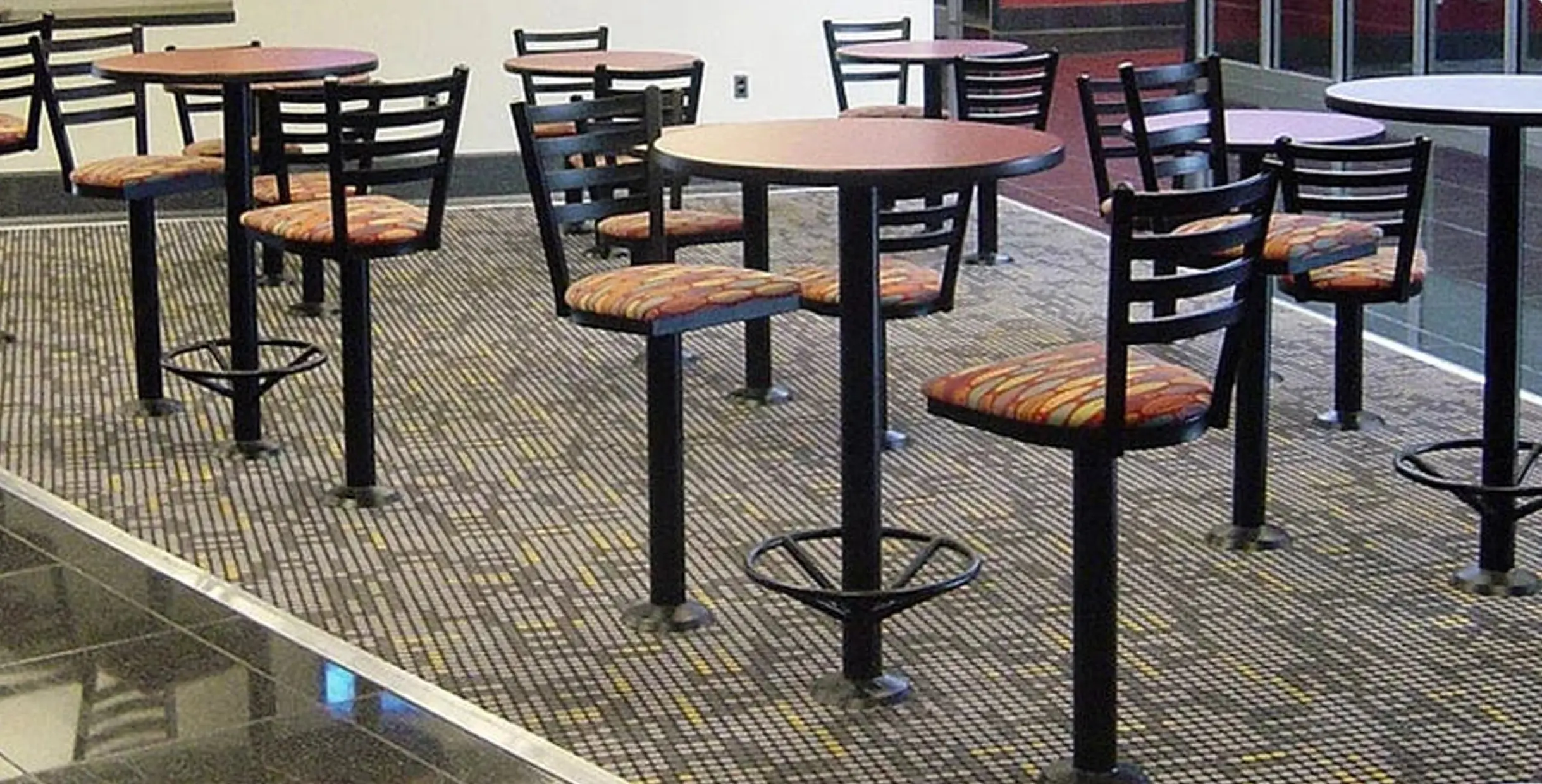 Best Place to Buy Restaurant Furniture Table Base in 2025: Online & Offline4 Fixed restaurant table bases with attached chairs and colorful upholstery in cafeteria layout