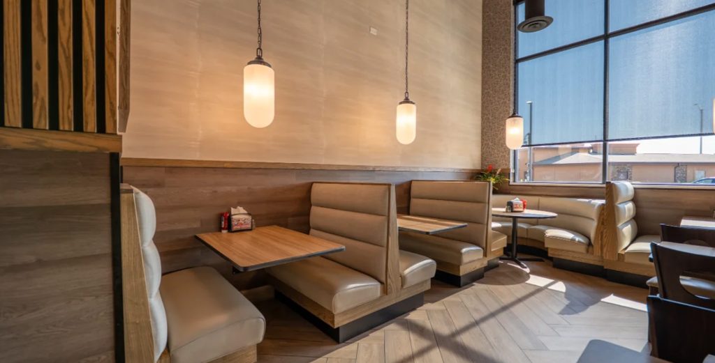 Custom Restaurant Booths | Design, Build & Installation Process 20253 Modern restaurant interior featuring tan leather booth seating and wood tables under warm pendant lighting
