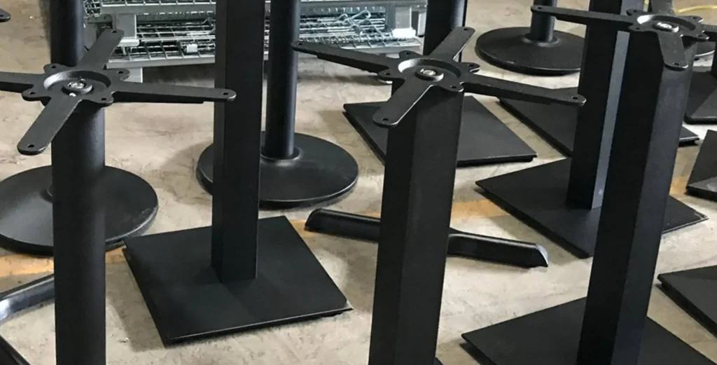Best Place to Buy Restaurant Furniture Table Base in 2025: Online & Offline2 Black metal restaurant furniture table bases lined up in Mingmeng factory workshop